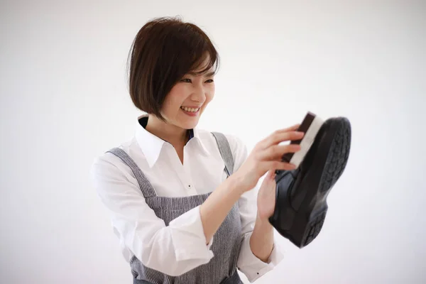 Woman polishing leather shoes
