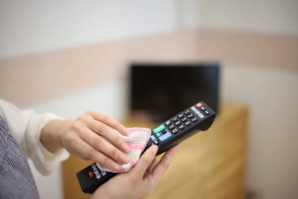 Woman Wiping Remote Control — Stock Photo, Image