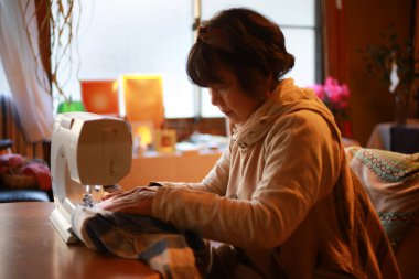 Dikiş makinesi kullanan bir kadın. 