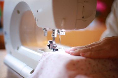 Dikiş makinesi kullanan bir kadın. 