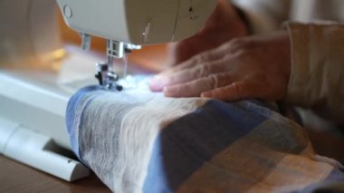 Dikiş makinesi kullanan bir kadın. 