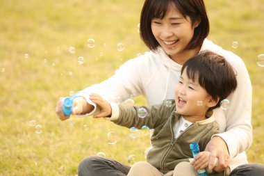 Ebeveynler ve çocuklar sabun köpüğüyle oynuyorlar