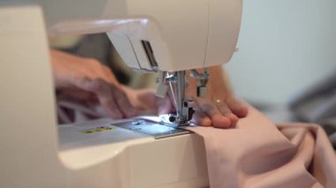 Dikiş makinesi kullanan bir kadın. 