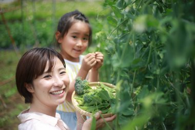 Ebeveynler ve çocuklar erişte yapma makinesi kullanıyorlar.