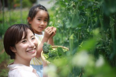 Ebeveynler ve çocuklar erişte yapma makinesi kullanıyorlar.