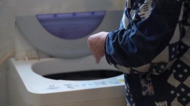 Çamaşır makinesini çeviren kadın