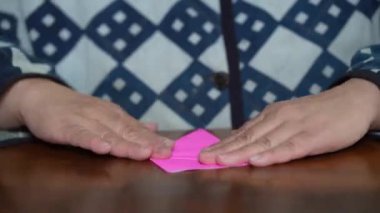 Turnayı origamiyle katlayan bir kadın.