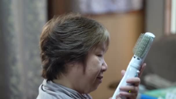 Старша Жінка Сушить Укладає Волосся Електричним Пензлем — стокове відео