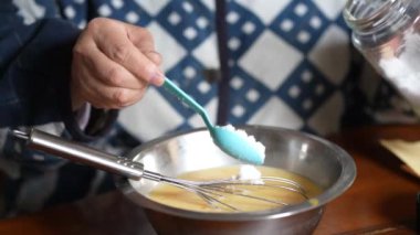 Yumurta suyuna şeker koyan bir kadın