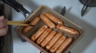 Sosis pişiren bir kadın resmi