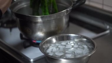 Haşlanmış ıspanağı buzlu suya batıran bir kadın.