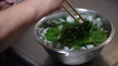 Haşlanmış ıspanağı buzlu suya batıran bir kadın.