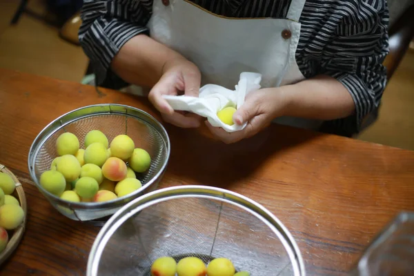 A woman who drains the washed plums