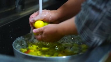 Image of a woman washing plums