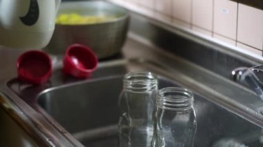 Woman disinfecting bottles with boiling water