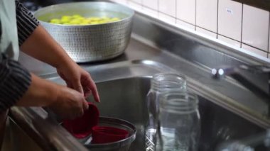 Şişeleri kaynar suyla dezenfekte eden kadın.