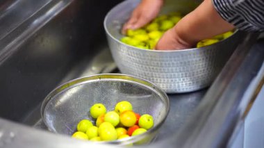 Image of a woman washing plums