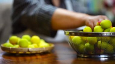 A woman who drains the washed plums