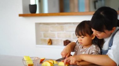 Ebeveyn ve çocuk elma kesiyor