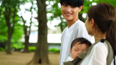 Ebeveynler ve çocuklar parkta yürüyorlar.