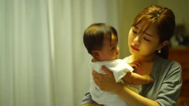 Anne çocuğunu uyutuyor.