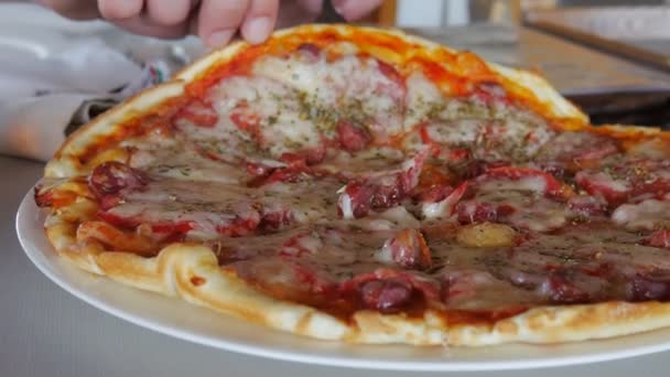 Di restoran di meja dengan tangan Anda mengambil sepotong pizza dengan keju yang renyah — Stok Video