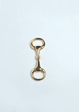 Altın kaplama at yarışı ayakkabısı aksesuarı beyaz arkaplanda izole edildi