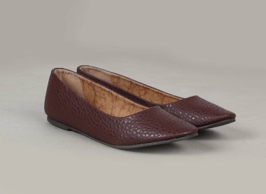 Kahverengi desenli düz topuklu bayan balerin beyaz arka planda izole edilmiş. 