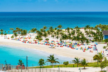 Bahamalar 'daki Ocean Cay' de sandalyeler ve şemsiyelerle sahile.