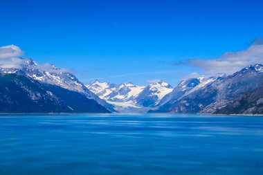 View from cruise ship in Glacier Bay Alaska of snow capped mountains clipart