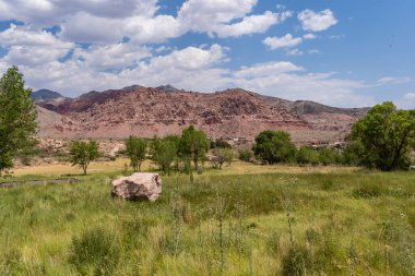 Kızıl Kaya Kanyonu manzarası. Çayırda büyük bir kaya var.