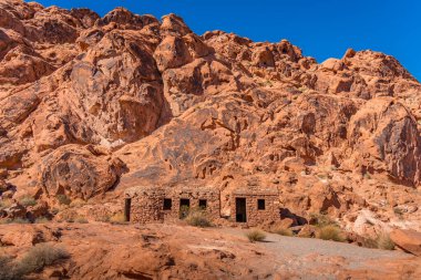 Dağın eteklerine kurulmuş, Nevada 'daki Fire State Park Vadisi' nde kerpiç tarzı kulübeler.
