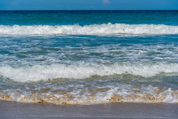 Okyanusta dalgalar süzülüyor ve kumsalda kumlu kıyılar