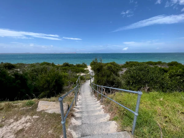 Escaleras sinuosas de playa que conectan plantas de playa verdes con el océano — Foto de Stock