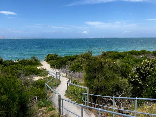 Escaleras sinuosas de playa que conectan plantas de playa verdes con el océano — Foto de Stock