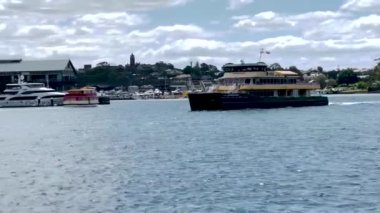 Sydney 'deki Barangaroo feribot iskelesinden geçen bir feribot. Sydney 'de insanların gidip gelmesi için toplu taşıma.