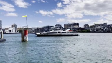 Sydney 'deki Barangaroo feribot iskelesinden geçen ve kenetlenen bir yat. Sydney 'de insanların gidip gelmesi için toplu taşıma.