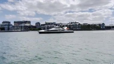 Sydney 'de Barangaroo iskelesinden geçen bir yat. Sydney 'de insanların gidip gelmesi için toplu taşıma.