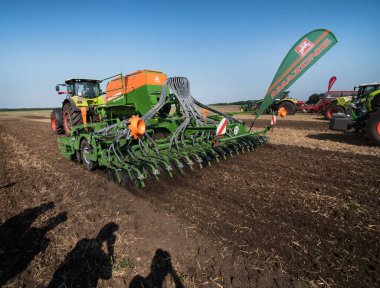Bilogirya, Khmelnytsky bölgesi, UKRAINE - 19 Ağustos 2021: Çiftçiler toprağı hazırlıyor ve ekici Amazone Cirrus 6603 gübre işlevi ve tohumlama kontrol sistemi ile Traktör ekiyor ve ekiyor.