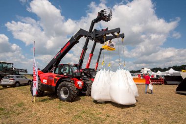 Belogorye, Khmelnytsky bölgesi, UKRAINE - 19 Ağustos 2021: Sergide Manitou 'ya torbalar dolusu tohum yükleyin. Traktör bir tarlaya park etmiş, yanında da 1000kg 'lık bahar tohumları taşıyor.