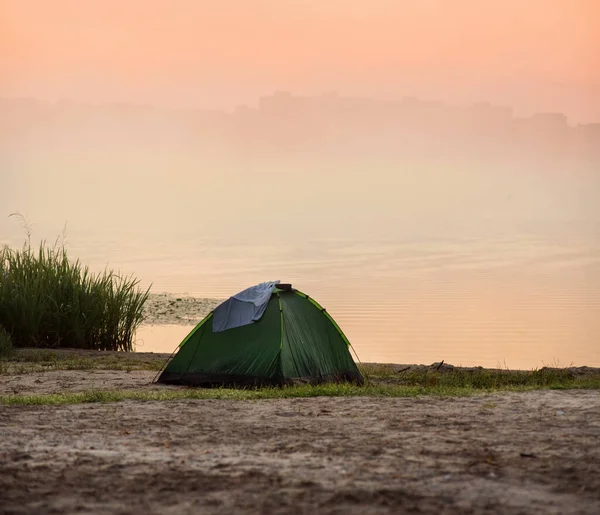 Morning sunrise, dawn, lakeside tent and fog