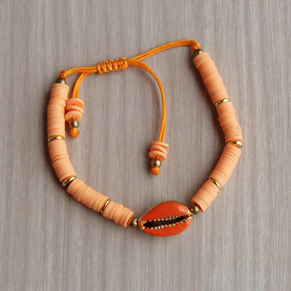 Kadın turuncu kabuklu moda bileziği. Yaz plajı kadın modası.