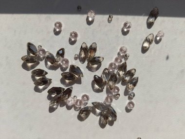 Masaya saçılmış boncuklar güneşi yansıtır. 