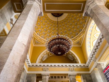 İstasyonun sarı duvarları, büyük bir avize. 