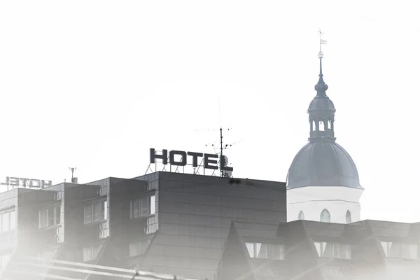 Dach Domu Hotelowego Którym Wystaje Wieża Kościelna Zdjęcie Jest Prawie — Zdjęcie stockowe