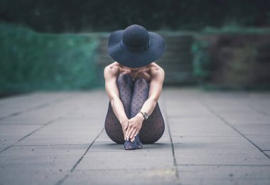 Doğada taş karoların üzerinde oturan bir kız. Kızın arkasında yeşil bir orman var. Kadının kafasında siyah bir şapka ve ayaklarında benekli çoraplar var. Bir kadın meditasyon yapar ve doğayla birleşir..