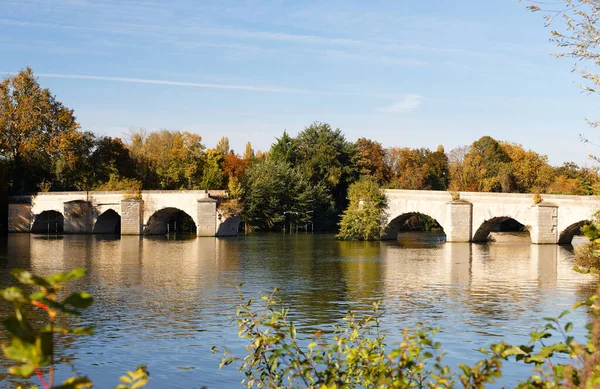 The old medieval broken arch bridge over the Seine river in Mantes-la-Jolie, Parisian region, France.