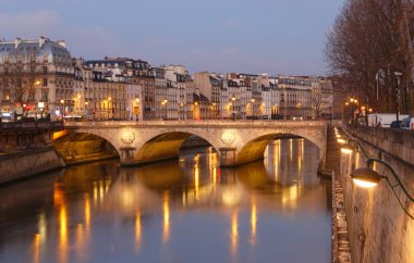 Paris 'te alacakaranlıkta taş köprü Pont au Change. Solda Conciergerie kuleleri var, Seine nehrinin kuzey kıyısında. Paris mi? Fransa.