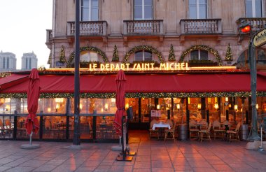 Paris, France- December 18 , 2021 : The traditional French cafe Le Depart Saint Michel decorated for Christmas 2021 . It located in Saint German district in Paris, 18 December , 2021. clipart