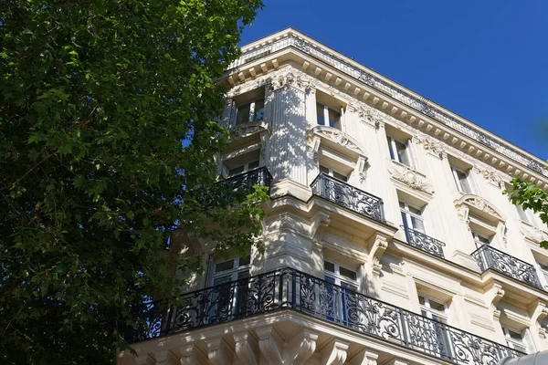 The facade of traditional French house with typical balconies and windows. Paris, France.